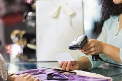 Clothing store cashier scanning price tag at checkout - 58475856_XXXLarge.e796de60