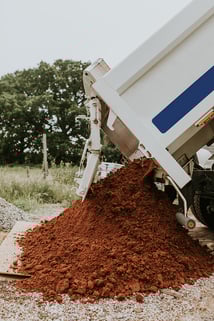 sand-truck-unloading-soil-on-a-construction-site-2023-11-27-05-26-50-utc
